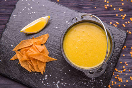 Lentil soup with toasts and a lemon, is served in a pig-iron kettleの写真素材
