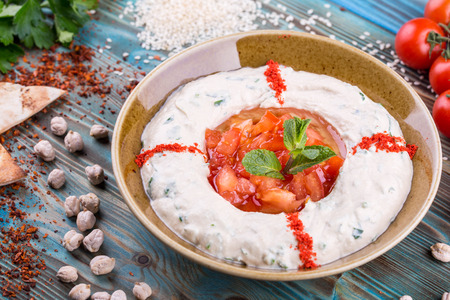 The wiped chick-pea with sesame paste, with tomato and parsley, with olive oilの写真素材