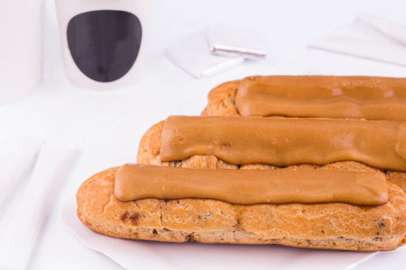 A classical eclair with chocolate, coffee and vanilla cream