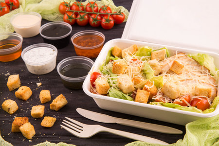Chicken fillet, salad salad iceberg, cherry tomatoes, garlick toasts and cheese parmesanの写真素材