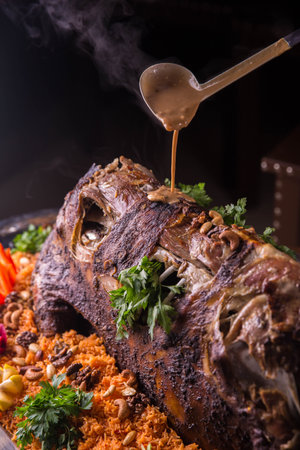 The baked ram with rice and vegetables on a big dish with sauce