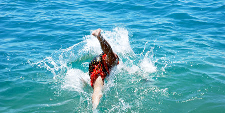 Jump into the water   	 Boy jumping into the waterの写真素材