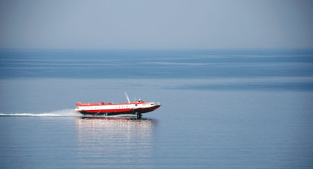 Red ferry on a background of blue sky and blue sea