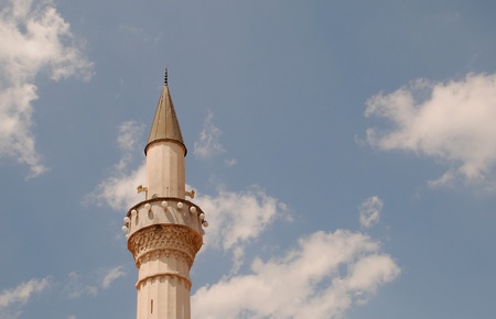 Minaret on a background of blue, cloudy sky の写真素材