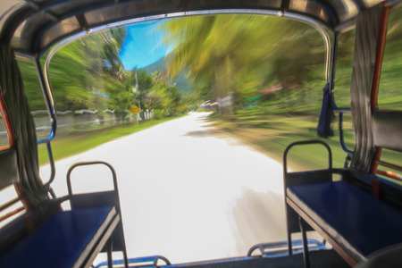 Traveling on the adventure ride 'Tuk Tuk' in southern island of Thailand.の写真素材