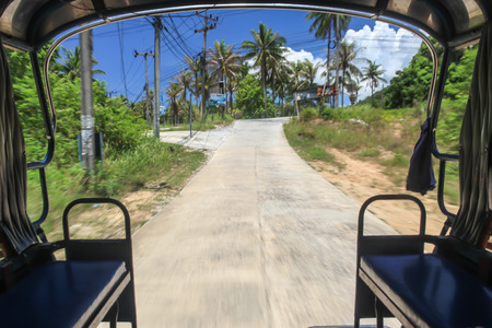Traveling on the adventure ride 'Tuk Tuk' in southern island of Thailand.の写真素材