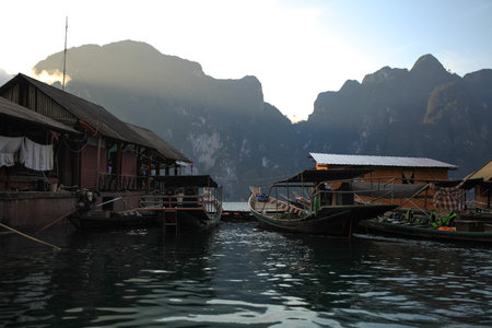 Houses on a raft on the lake Ratchaprafa Surat Thani in Thailand during sunset.