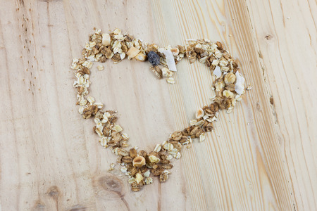Heart-shaped muesli and cereal on the wooden table.の写真素材