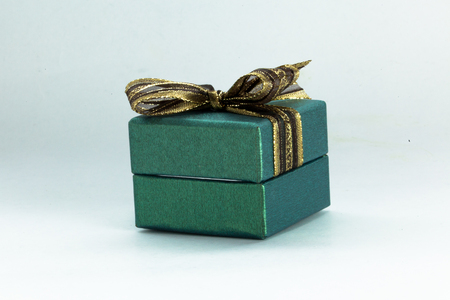 Green gift box with a green ribbon and bow in white isolated backgroundの写真素材