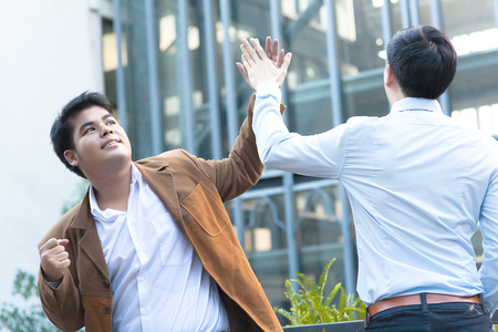 Young Diverse Asian Business Men Giving High Fiveの写真素材