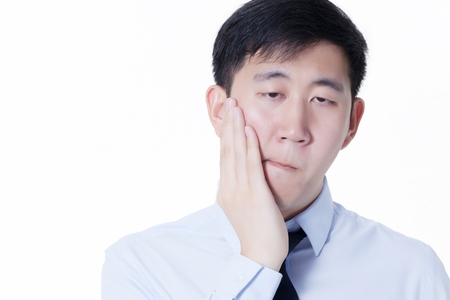 Young Asian man suffering from toothache / mouth problemsの写真素材