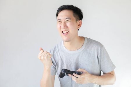 Young Asian man playing video games - in white isolated backgroundの写真素材