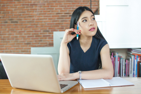 Asian Woman Thinking and Working in modern officeの写真素材