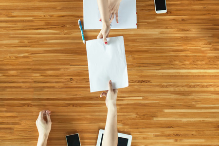 Closeup Top View of People handing out documentsの写真素材
