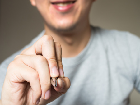 Man holding pen, writing and drawing in the air with copy spaceの写真素材