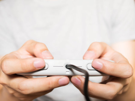 A young man holding game controller playing video games