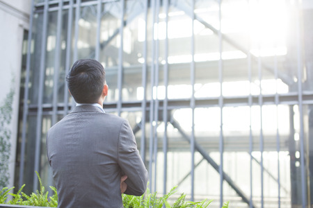 Ambitious business man from the back - looking at glass building (Shallow depth of field)の写真素材