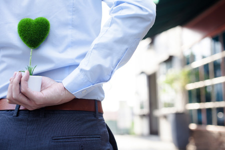 Man hands holding surprise gift from behind - love and relationship conceptの写真素材