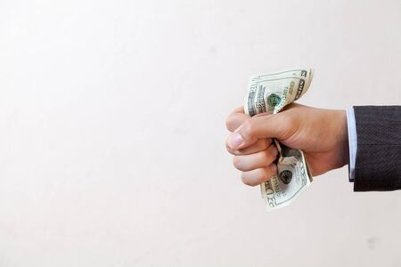 Businessman squeezing bank notes in white isolatedの写真素材