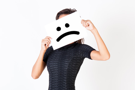 Woman in elegant dress holding dissatisfied face paper - unhappy and dissatisfied treatment conceptの写真素材