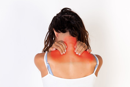 Young woman in tank top having neck pain isolated on white backgroundの写真素材