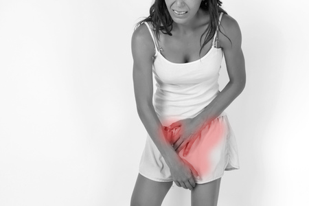 Woman having a stomachache / food poisoning / stomach problems / womb problems / menstruation pain (In Black and White Tone with Red Mark)の写真素材