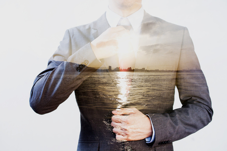 Double Exposure of businessman in offshore sunset sea backgroundの写真素材