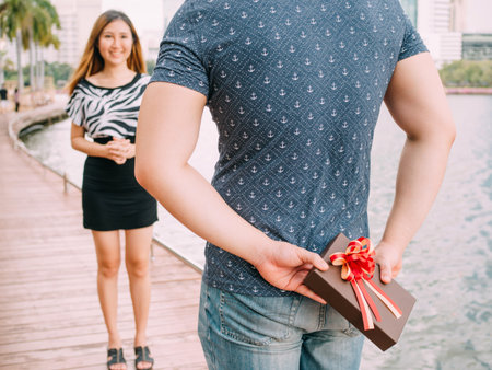 Man surprises his girlfriend by giving out a gift - love and relationship conceptの写真素材