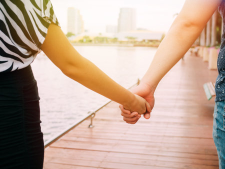 Couple in love holding hands with each other on the pierの写真素材