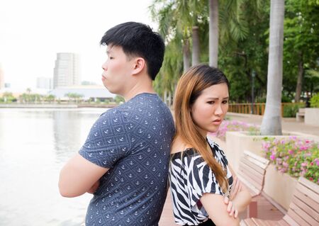 Asian couple being mad at each other in the parkの写真素材
