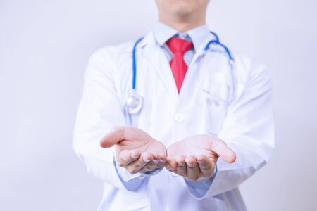 Doctor having product presentation gesture in white background.の写真素材