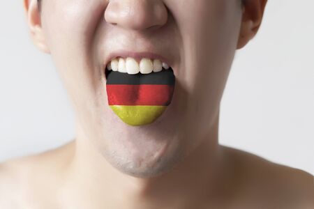 Germany flag painted in tongue of a man - indicating German language and speakingの写真素材