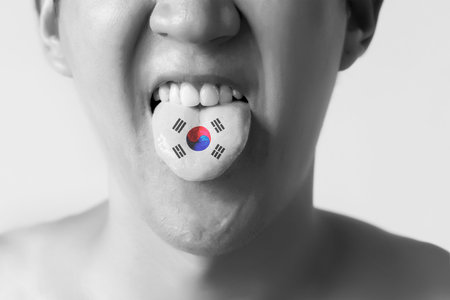 South Korea flag painted in tongue of a man - indicating Korean language and speaking in Black and Whiteの写真素材