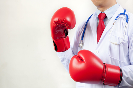 Doctor wearing boxing gloves in white backgroundの写真素材