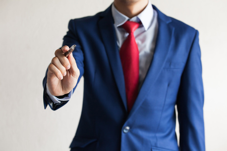 Closeup of young business man hand writing in the air as write on touch screenの写真素材
