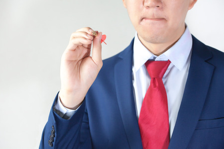 Businessman holding a dart aiming at the target - business targeting, aiming, focus concept.の写真素材