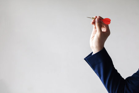 Businessman holding a dart aiming at the target - business targeting, aiming, focus concept.の写真素材