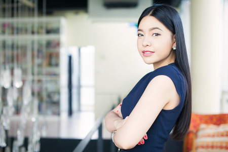 Asian woman having arms folded on office background (Focus on eyes)の写真素材