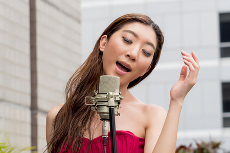 Asian woman singing on the rooftop of the building in outdoor scene.の写真素材