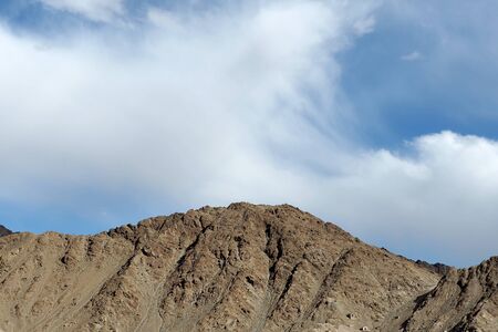 Top of rock mountain in blue cloud sky - with copyspace in Leh, Ladakh, India.の写真素材