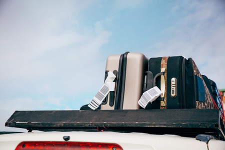 Luggages and Bags arranged on the car roof ready for a trip in sky backgroundの写真素材