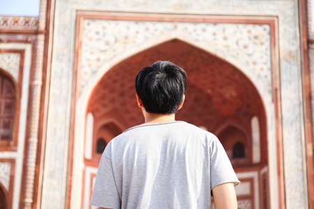 Young traveler walking towards entrance to Taj Mahal in Agra, India.の写真素材