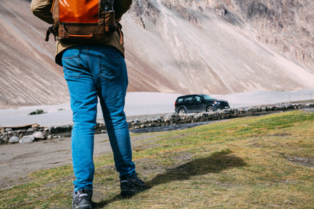 Back of young travel backpacker walking towards the highland mountain.の写真素材