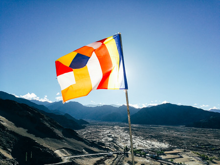 One single Buddhist prayer flag in six colors fluttering in mountain region against the sunlight. - The colorful flags can represent Tibetan culture and Buddhist religion symbol very well.の写真素材