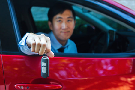 Young Asian businessman giving out a car key inside a carの写真素材