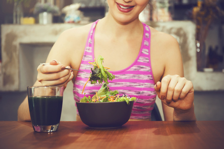 Attractive fitness woman is eating salad with healthy glass of juice - Fitness and Diet conceptの写真素材