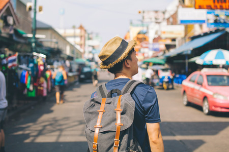 Young Asian traveling backpacker in Khaosan Road outdoor market in Bangkok, Thailandの写真素材