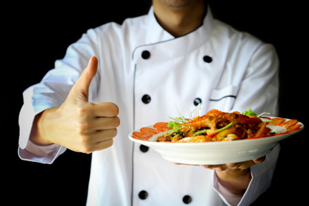 Chef proudly presenting Curry Crab with Coconut and showing thumbs upの写真素材