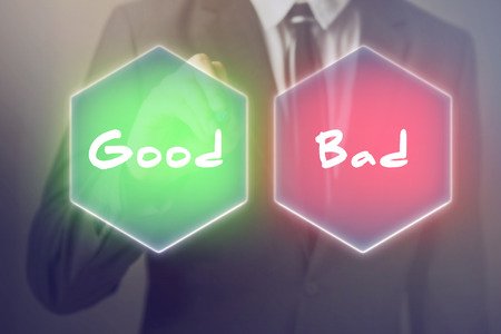 Businessman having to choose between good or bad decisionの写真素材