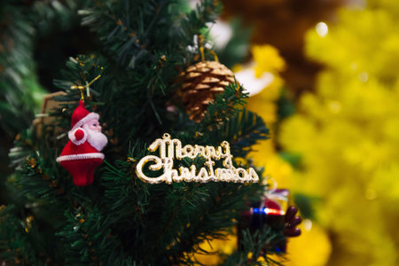 Merry Christmas text sign ornament attached on Xmas tree - selective focus.の写真素材